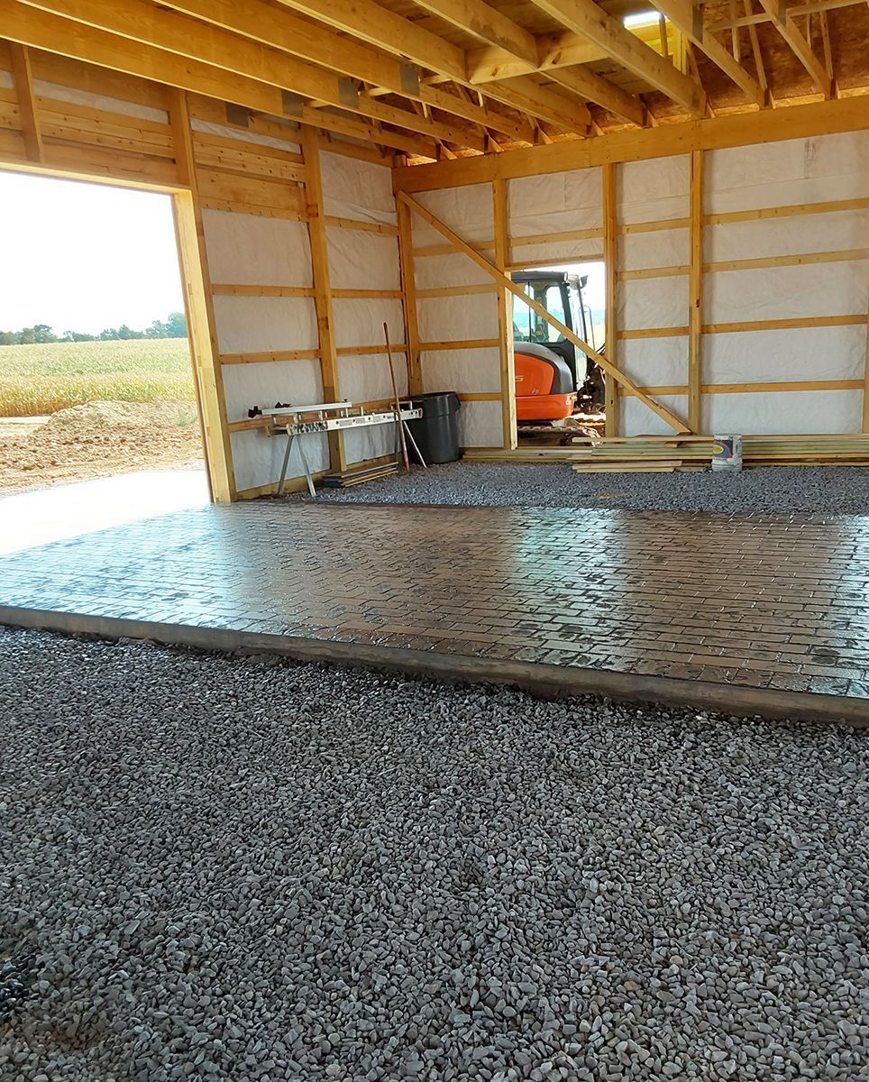 A tractor is parked inside of a building under construction.