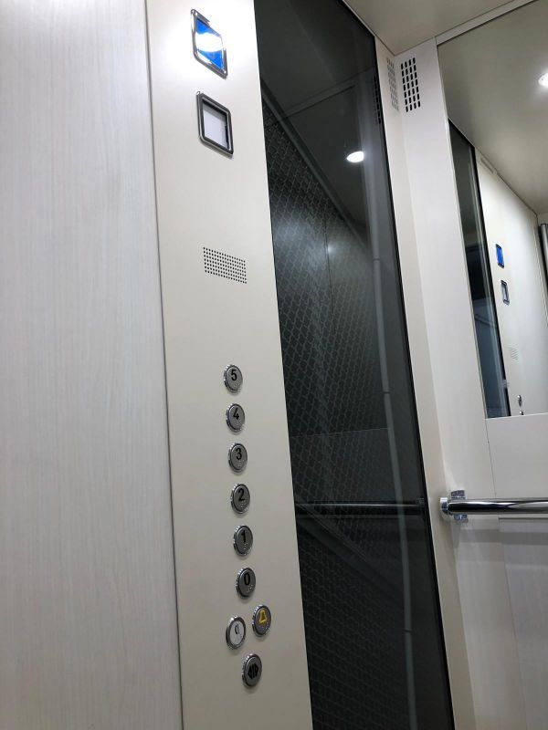 ascensore con pareti bianche e pulsanti grigi