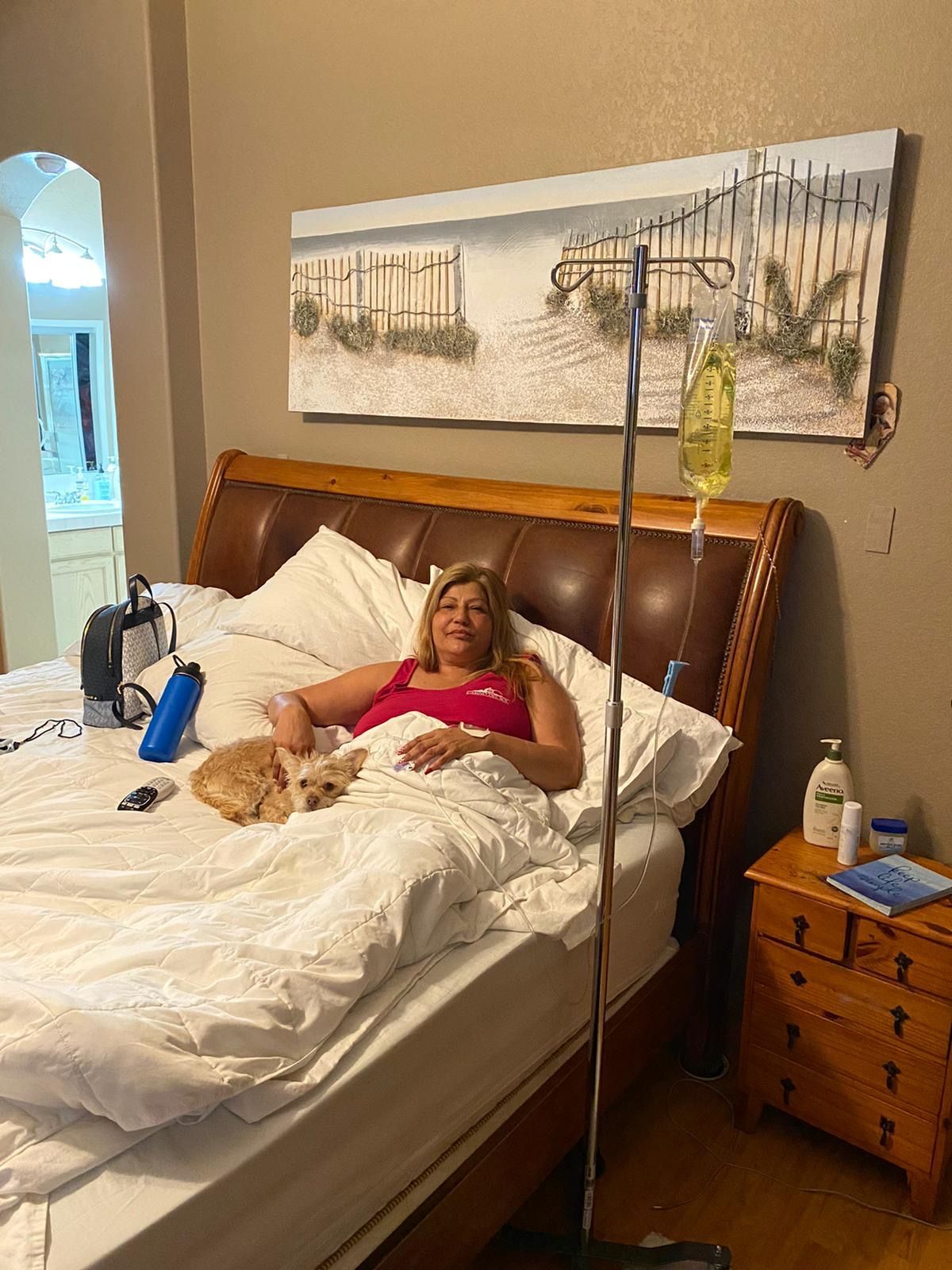 A woman is laying in a bed with an iv in her arm.