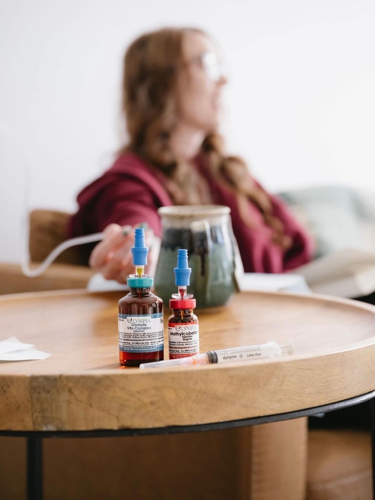 A woman with braids is holding a bottle of liquid in her hand.