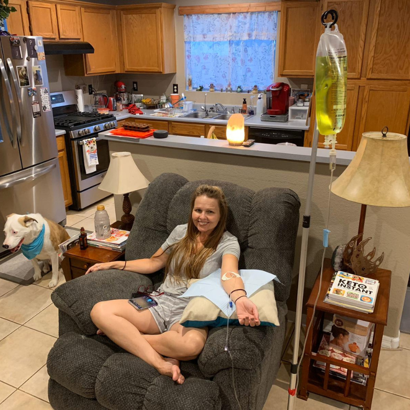 A woman is sitting in a chair with an iv in her arm