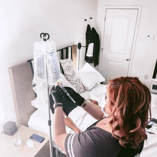 A woman with braids is holding a bottle of liquid in her hand.