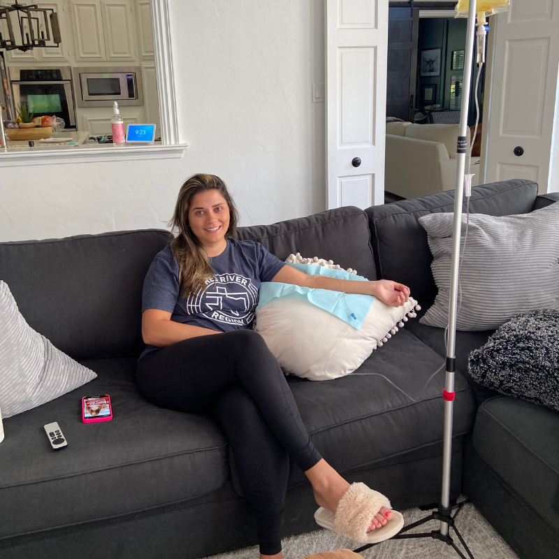 A woman is sitting on a couch wearing a t-shirt that says texas tech