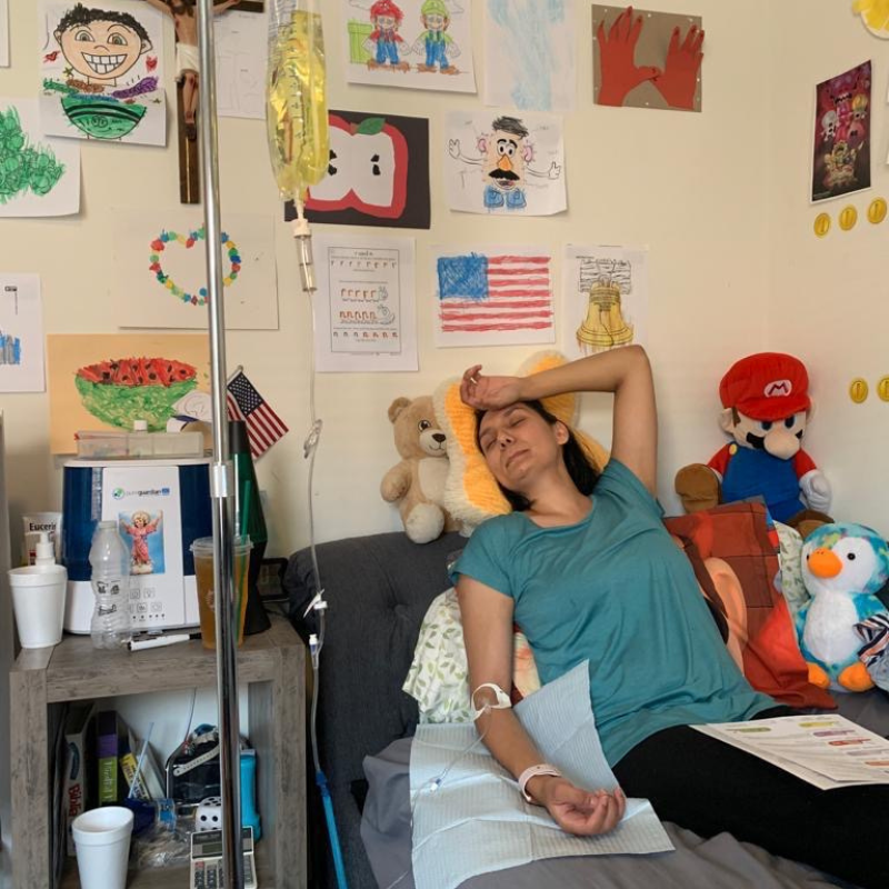 A woman is laying in a hospital bed with an iv in her arm
