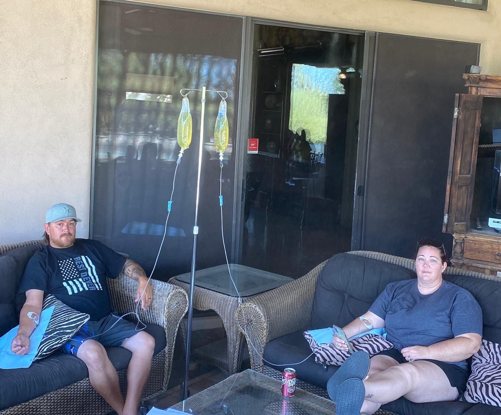 Two men are sitting next to each other in a hospital bed.
