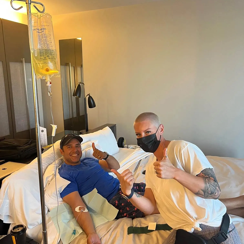 A woman is getting an injection in her arm in a hospital room.