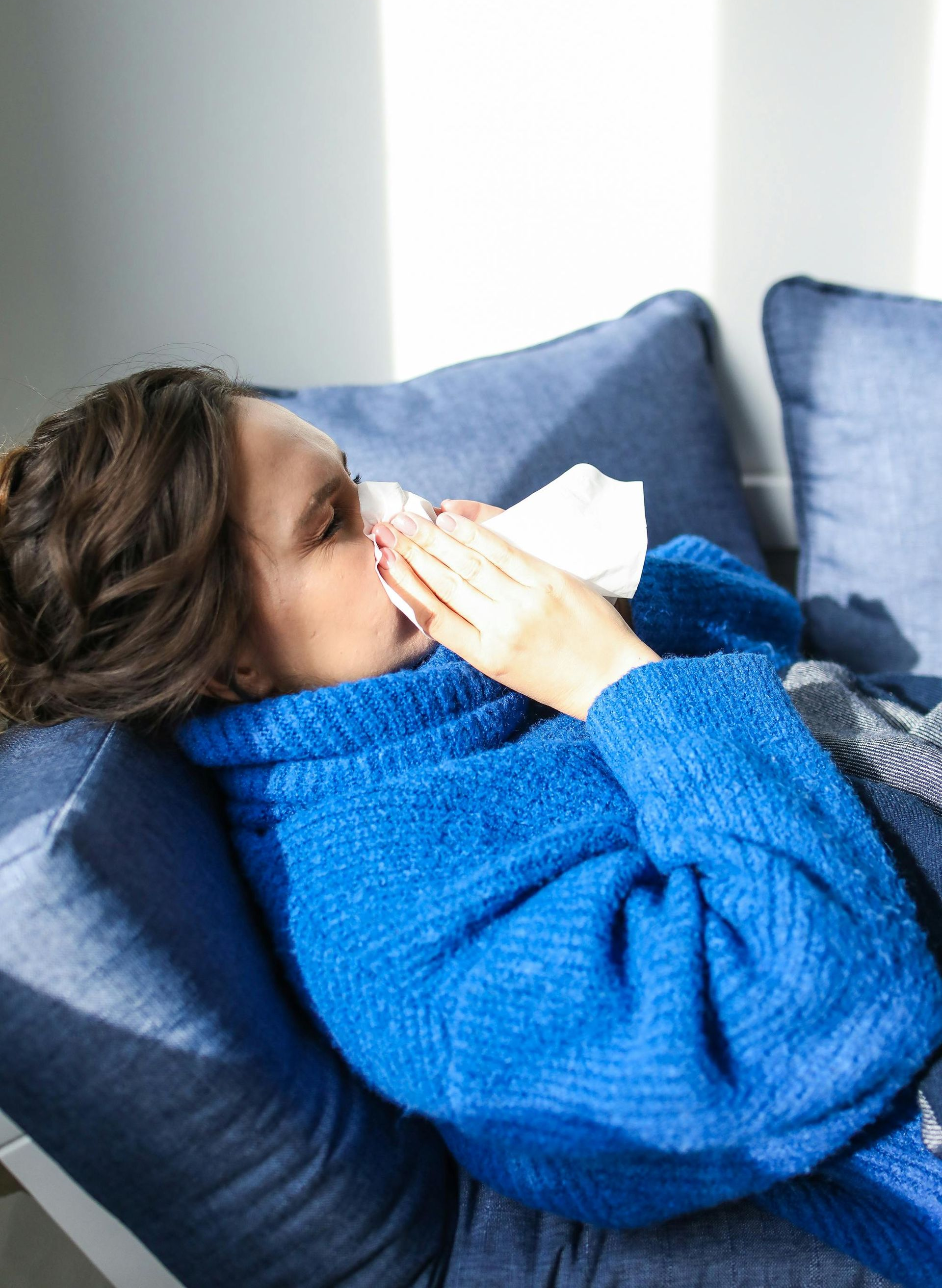 Two men are sitting on a bench with iv bags in their legs.