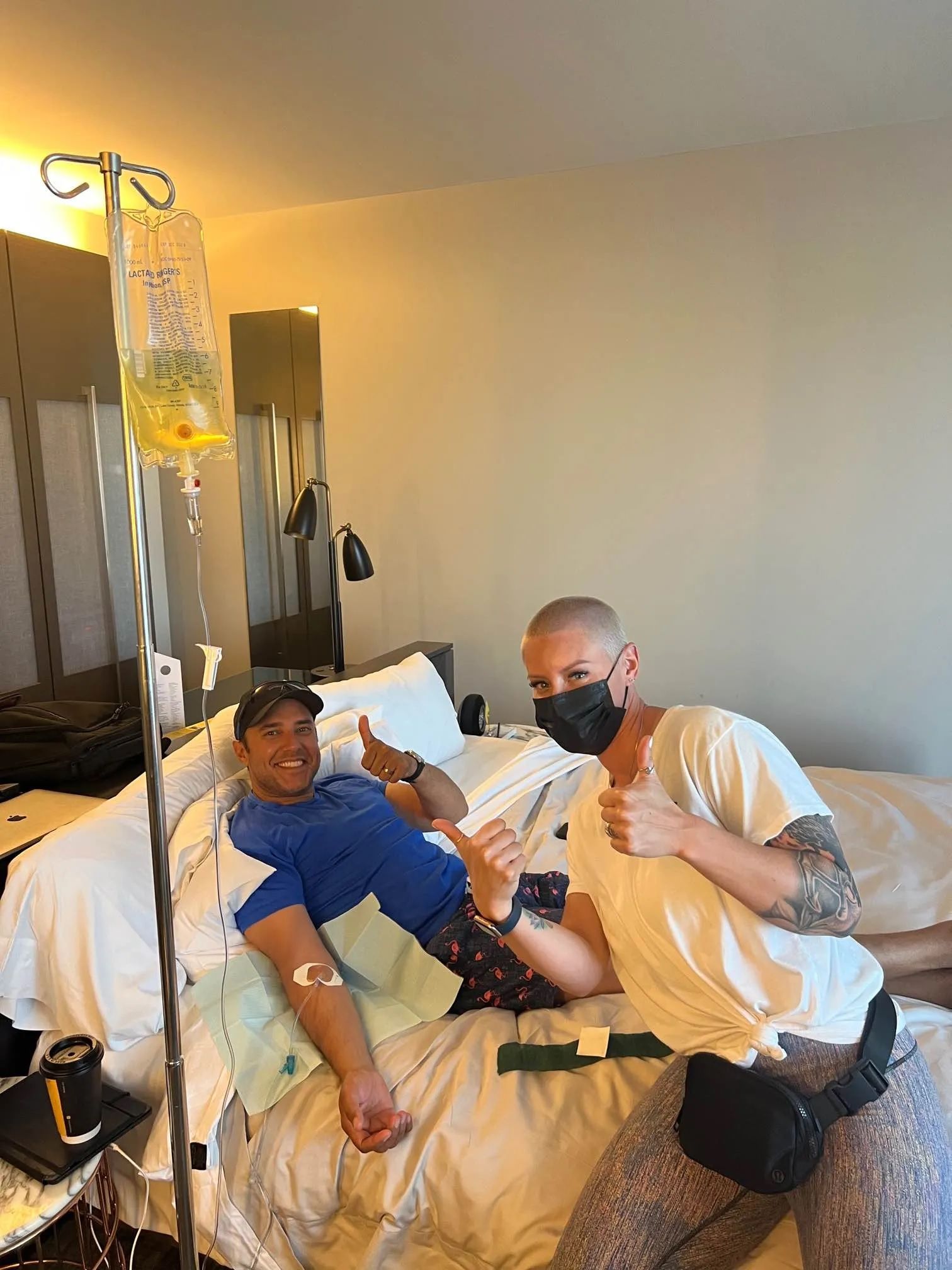 Two men are sitting next to each other in a hospital bed.