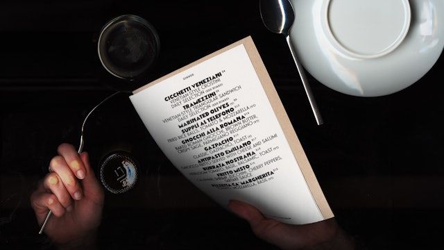 Restaurant and menu design, Bacàn, New York, featured in an article written by The End Creative Agency. A4 menu over a restaurant table.