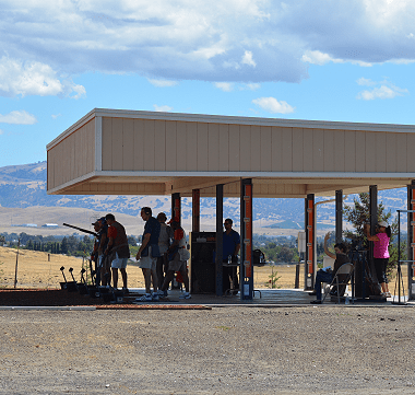 A group of people standing under a canopy in a field