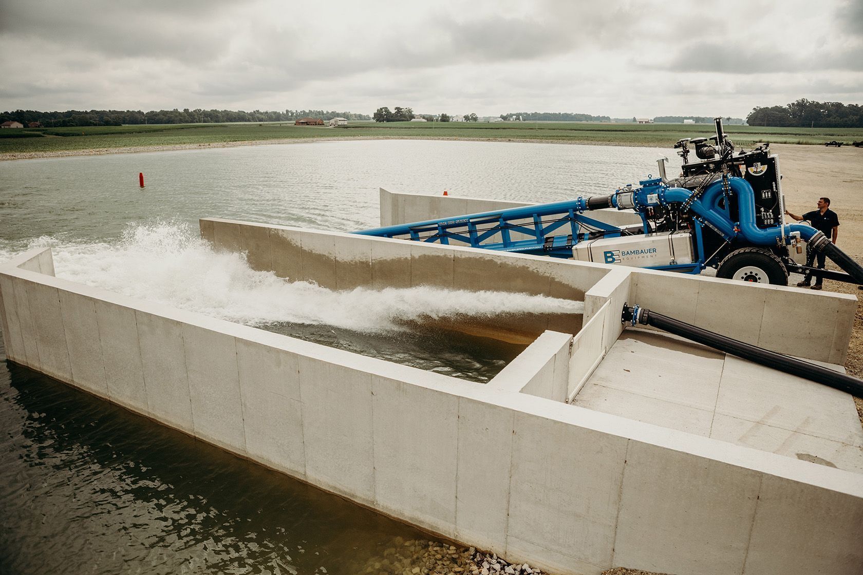 Water pumping station draining water through a concrete canal into a river or reservoir