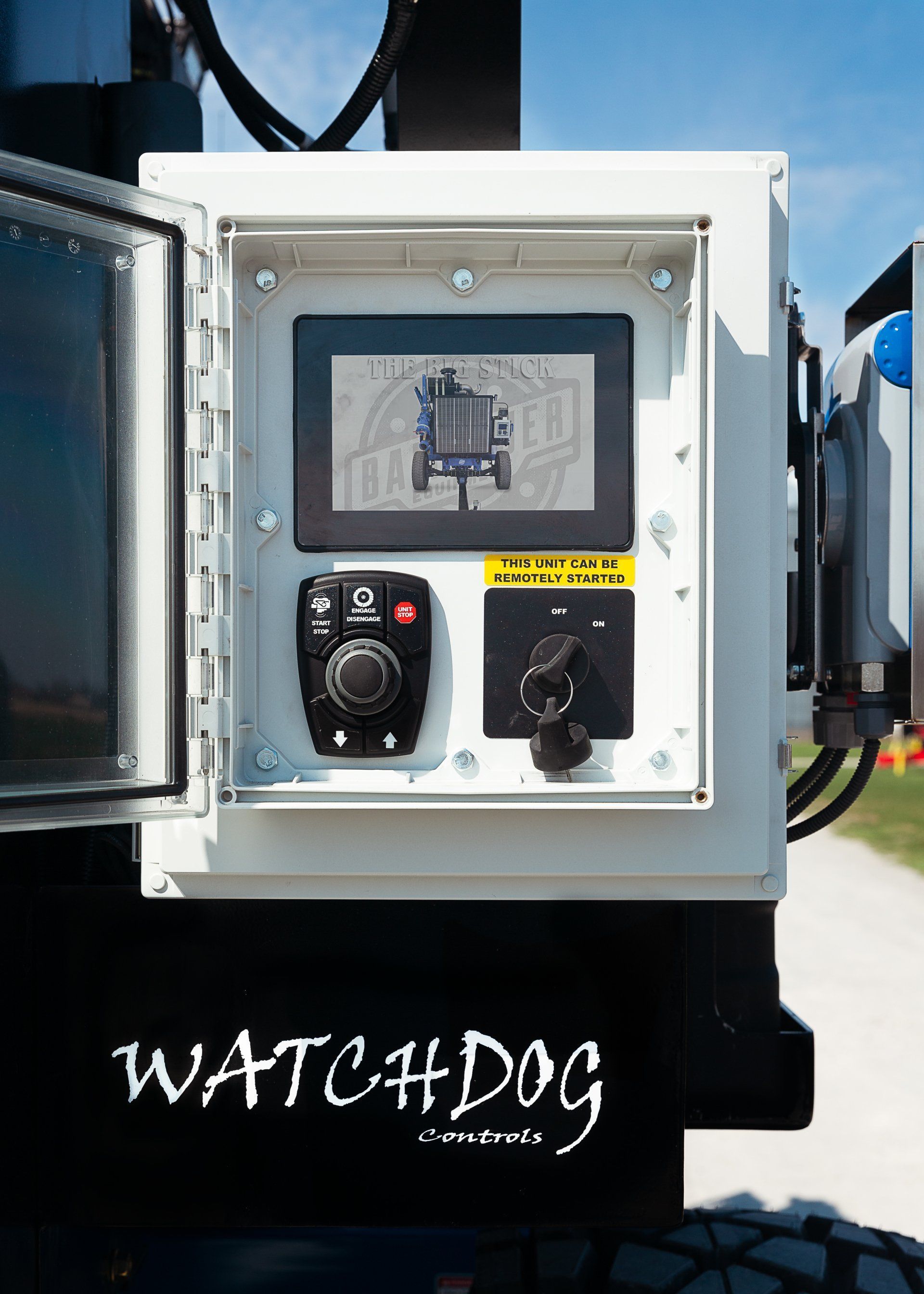 White control panel with screen and buttons on a black “WATCHDOG” machine outdoors.