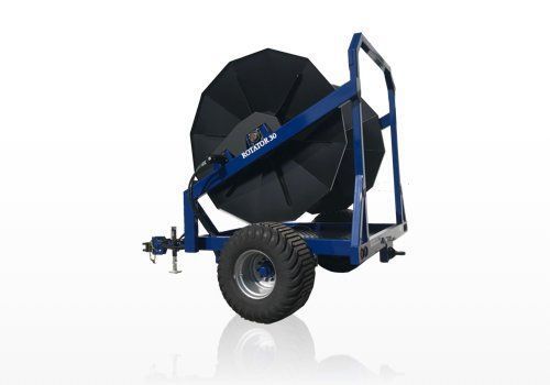 Blue wheeled agricultural reel on a trailer frame with large black drum and tires