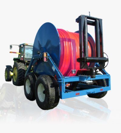 Tractor pulling a blue hose reel trailer with a large red hose spool on a white background