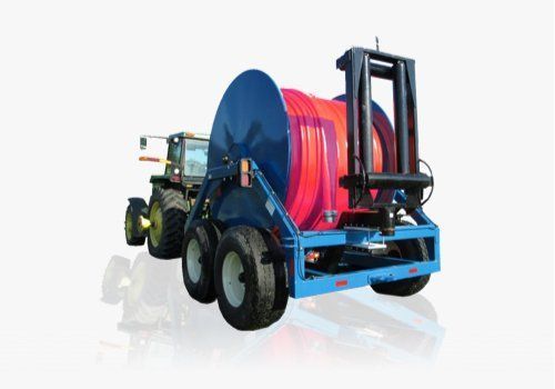 Tractor pulling a blue cable reel trailer with red hose on a white background