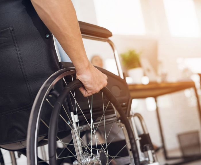 A person in a wheelchair is holding the wheel. A person in a wheelchair is holding the wheel.