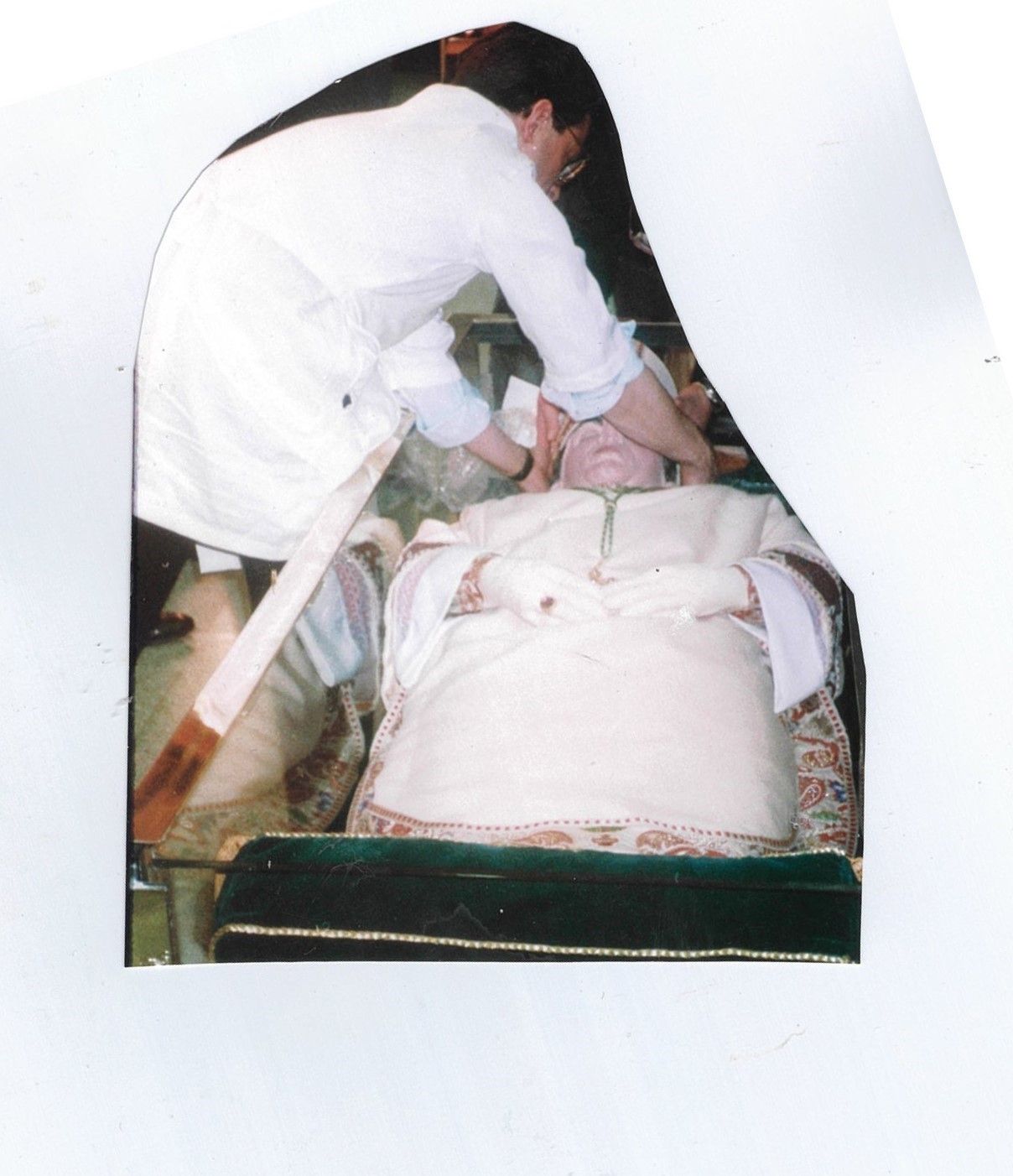 A man in a white coat is laying on a coffin