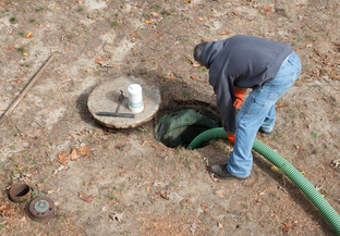 staff pumping sludge out of septic tank