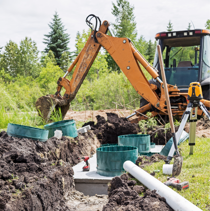 excavator digging around a newly installed septic tank