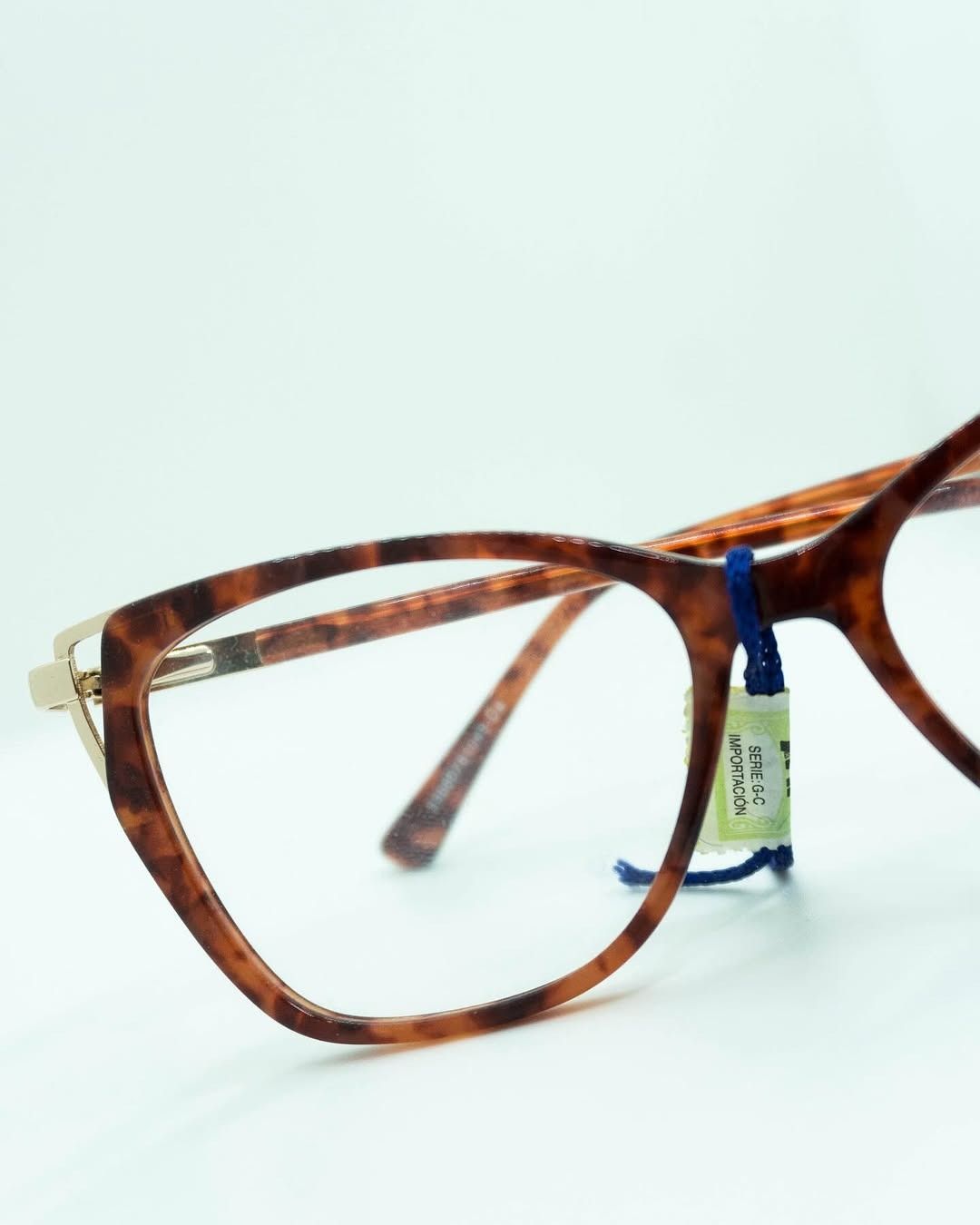 Gafas de carey marrón con detalles dorados, etiqueta de precio adjunta.