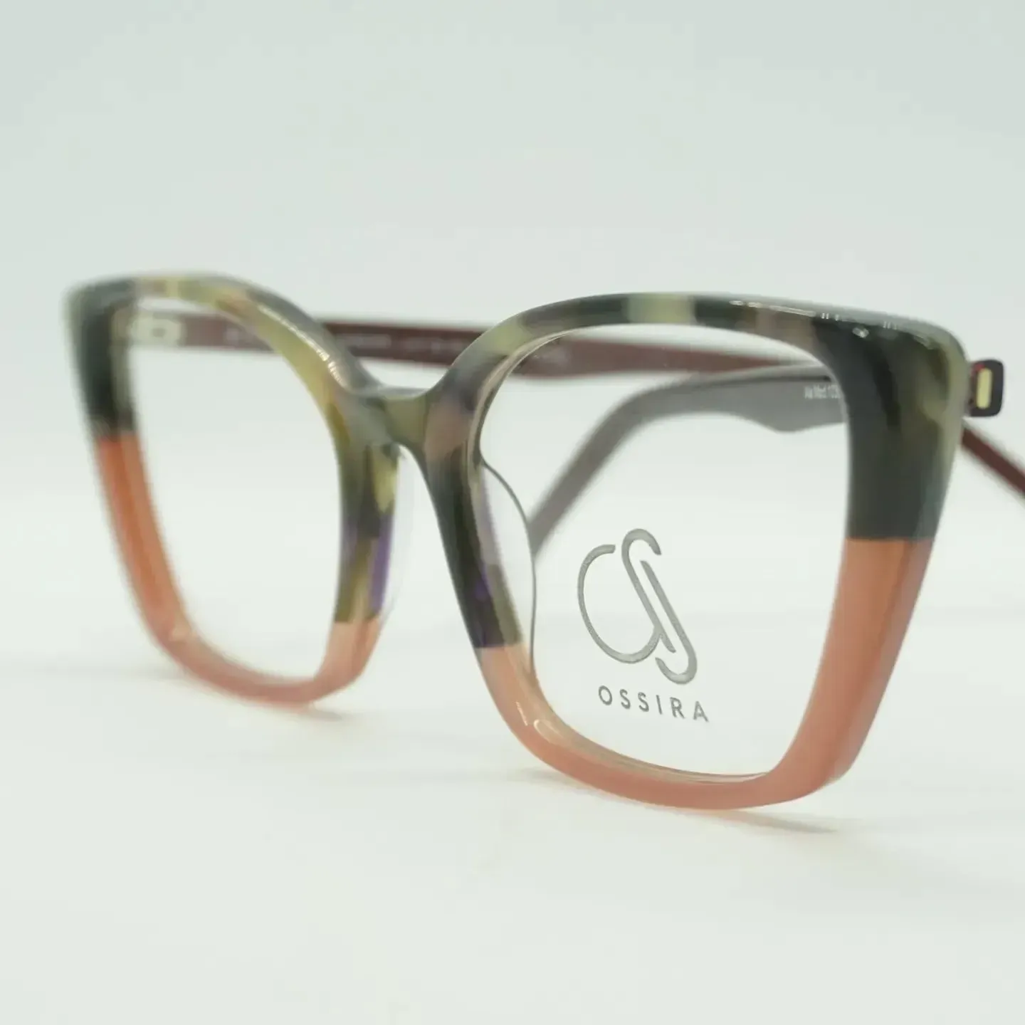 Gafas con montura gruesa y multicolor, con tonos rosa, verde y gris oscuro. Las lentes son transparentes.
