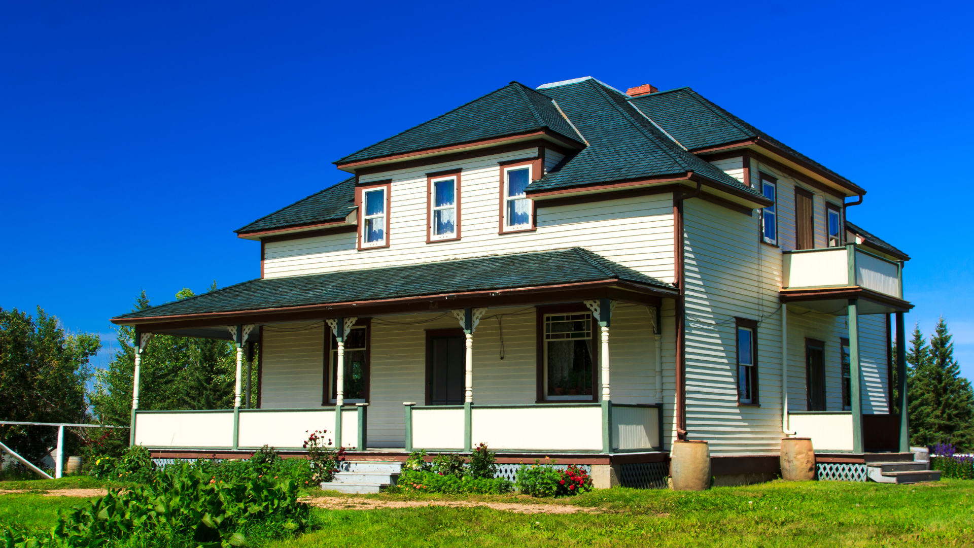 A white house with a green roof and a porch