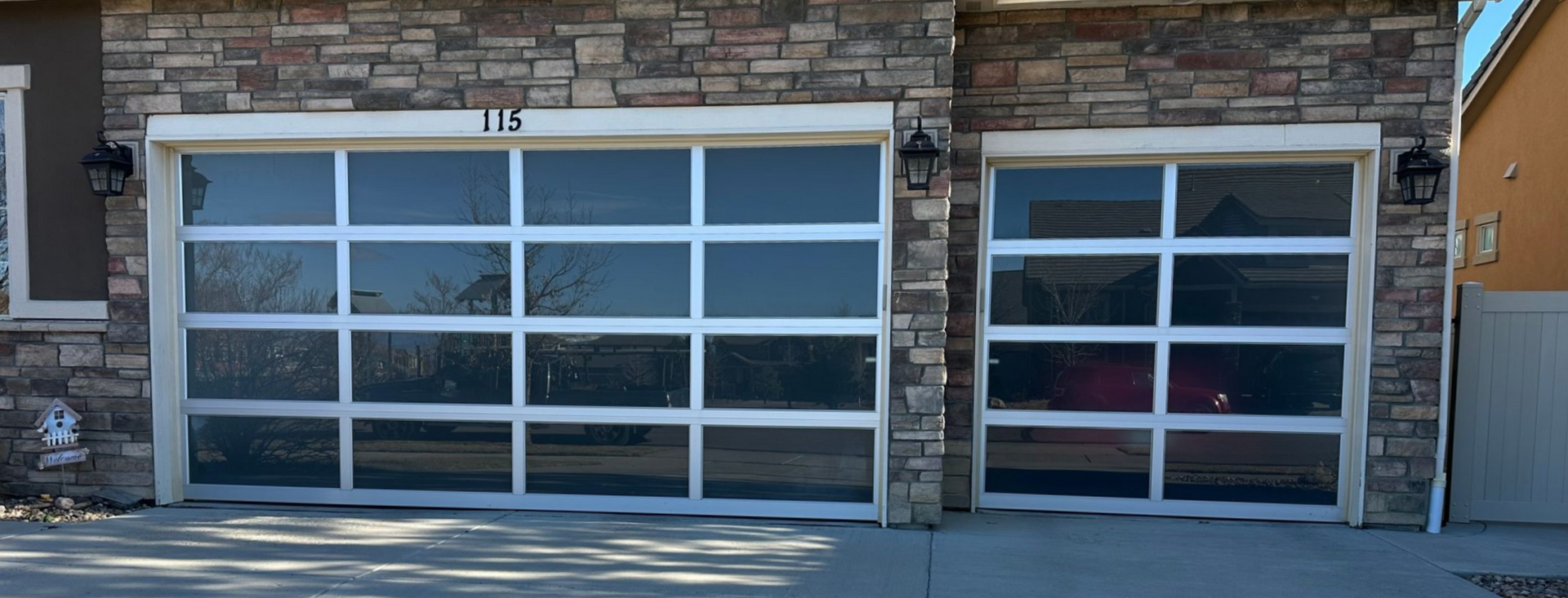 Two full view garage doors on a stone faced home