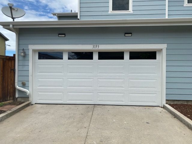 White garage door with glass panels above, address 
