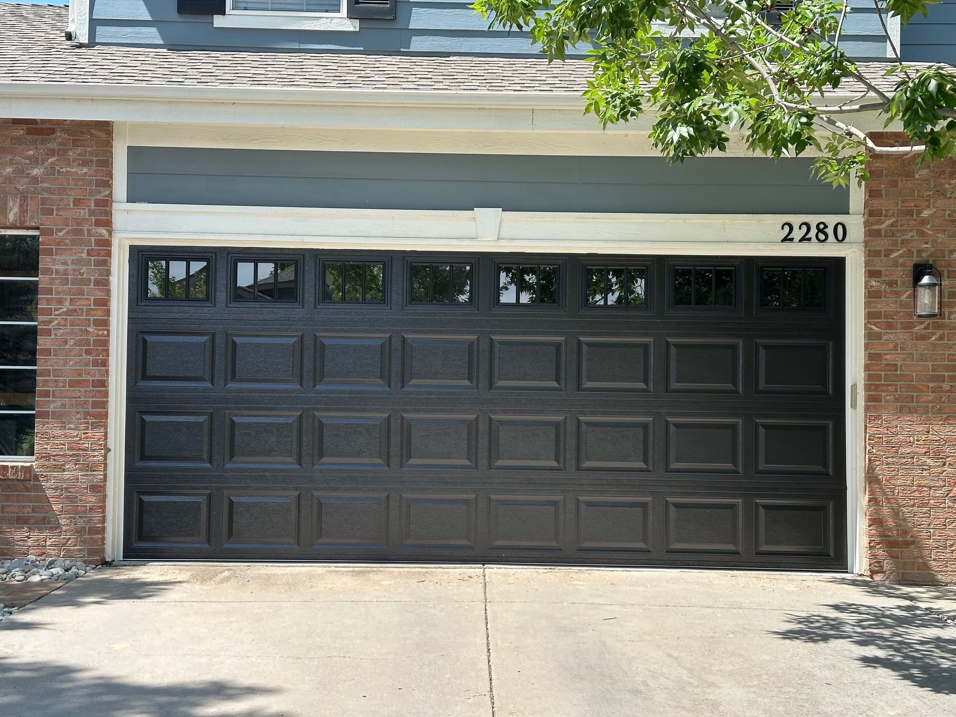 Black garage door with windows and address 