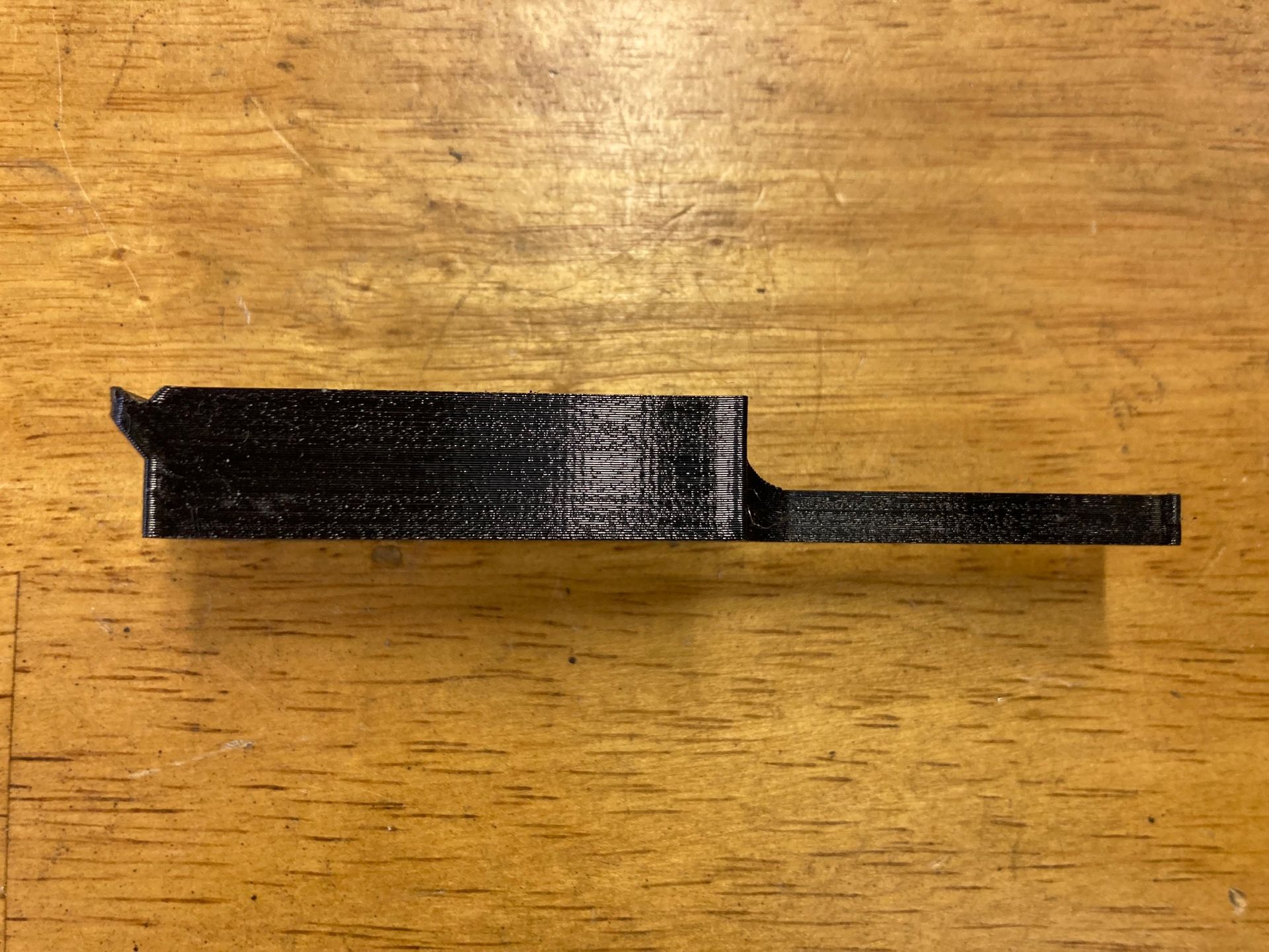 A black object is sitting on a wooden table.