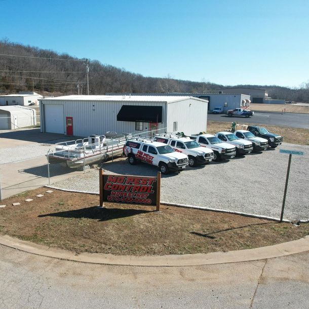 A row of white trucks are parked in front of a building. Missouri Pest Control (MOPEST)