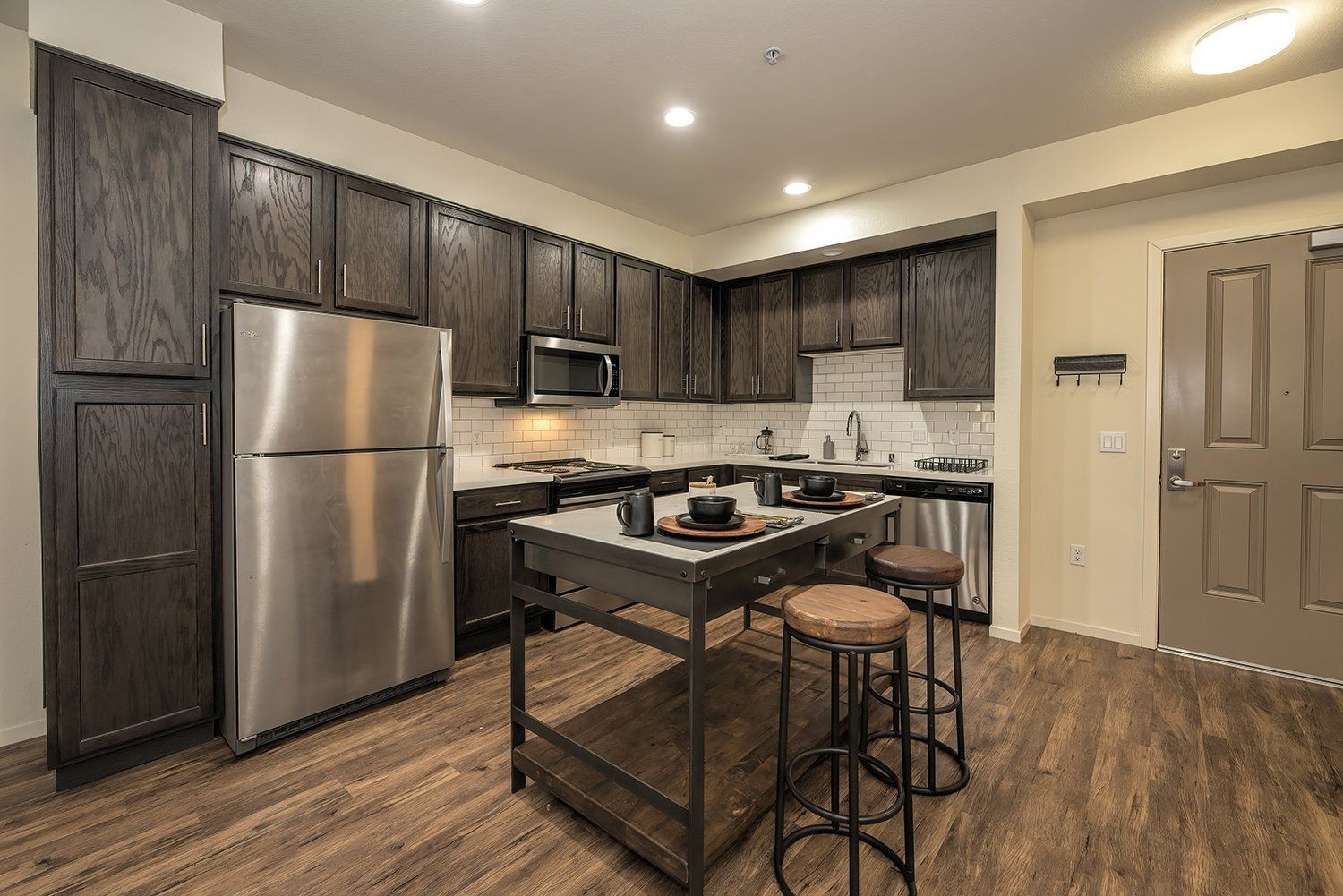 1-BR Apartments In El Cerrito, CA - Metro 510 - Kitchen With Hardwood Style Flooring, High Ceilings, Designer Cabinets, Stainless Steel Appliances, White Tile Backsplash, A Dishwasher, And A Built-In Microwave.
