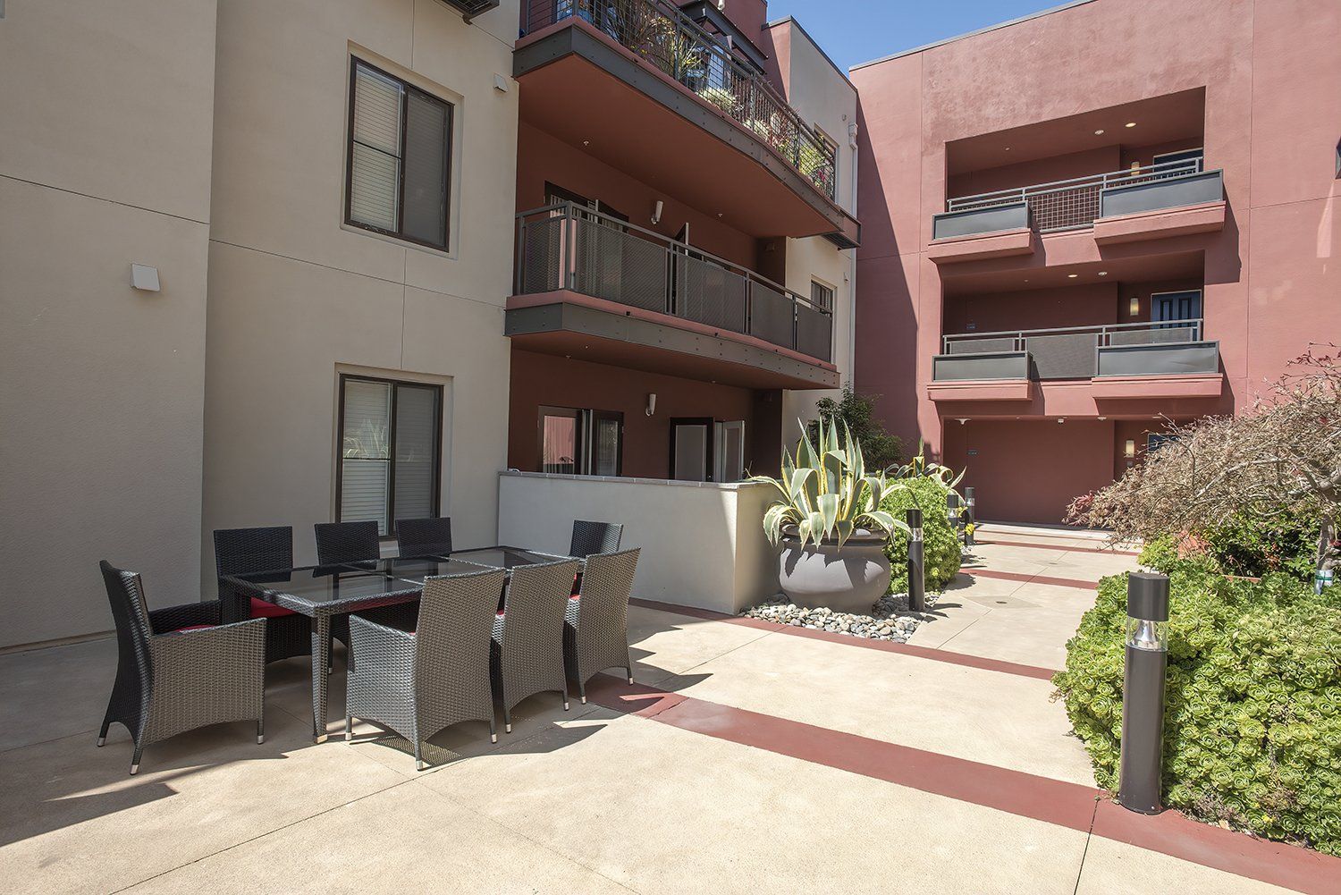 El Cerrito Apartments - Metro 510 - Courtyard In The Heart Of The Complex. The Courtyard Has Plush Seating, Stools, Lights, Potted Plants, And Maintained Landscaping.