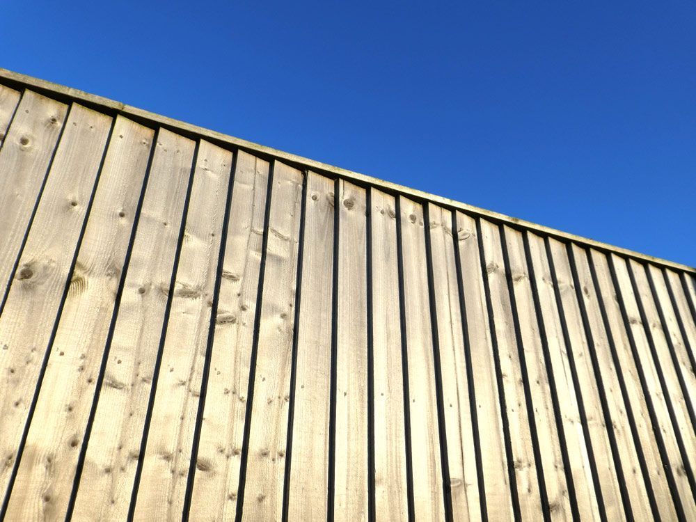 A Wooden Fence With a Blue Sky in the Background — Tony Eldridge Property Services in Forster, NSW
