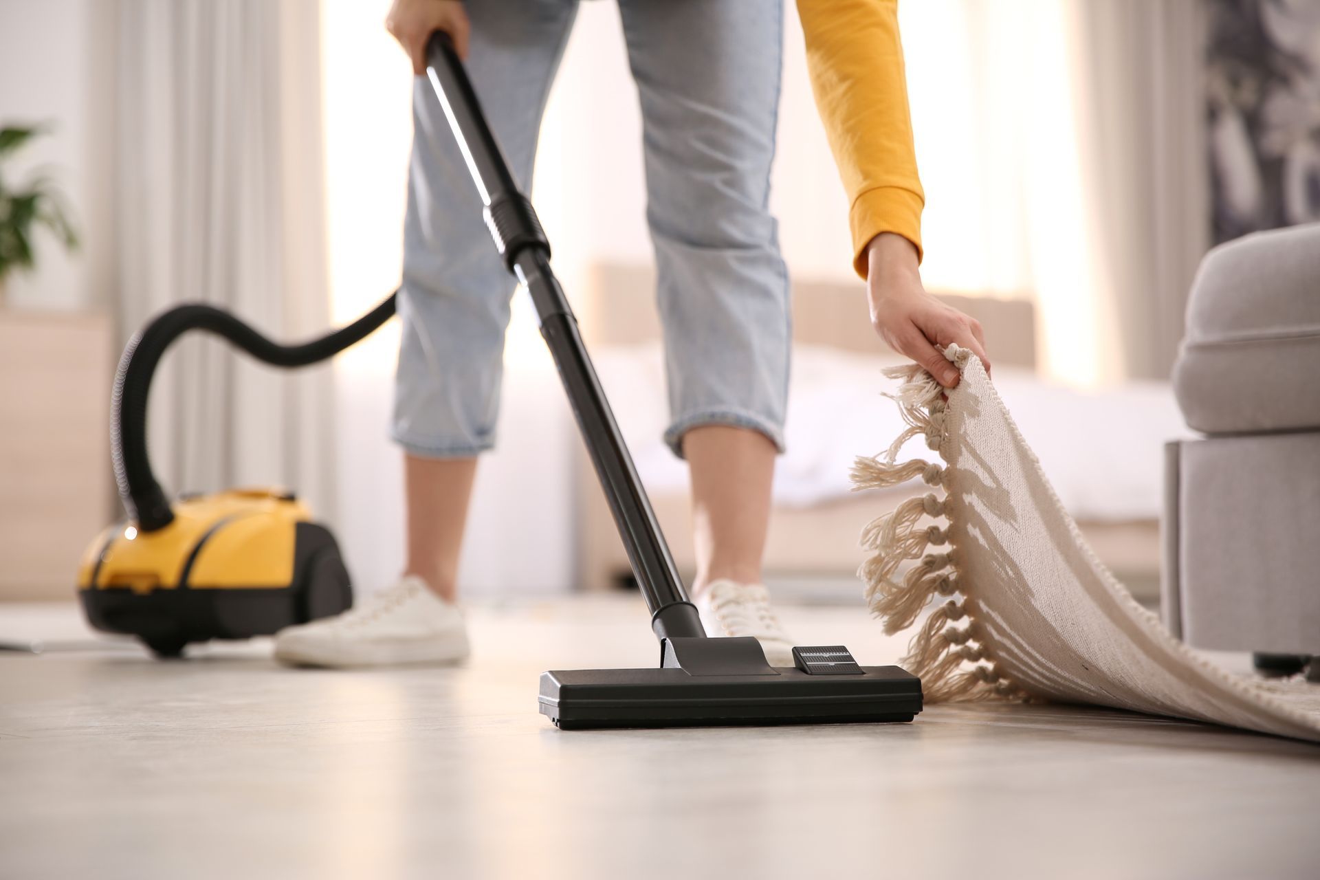 A young woman diligently cleaning her home with a vacuum cleaner, creating a tidy and comfortable living environment.