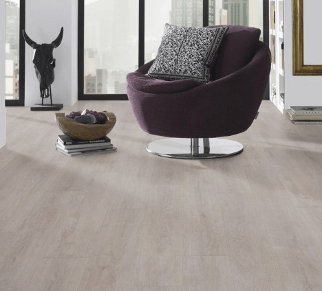 A living room with a purple chair and a bowl of fruit