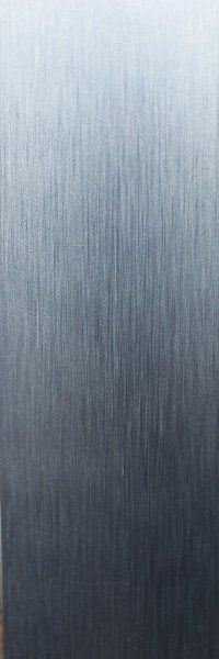 A close up of a stainless steel surface with a brushed finish.