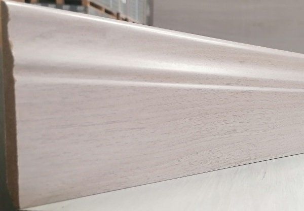 A white wooden skirting board is sitting on a white surface.