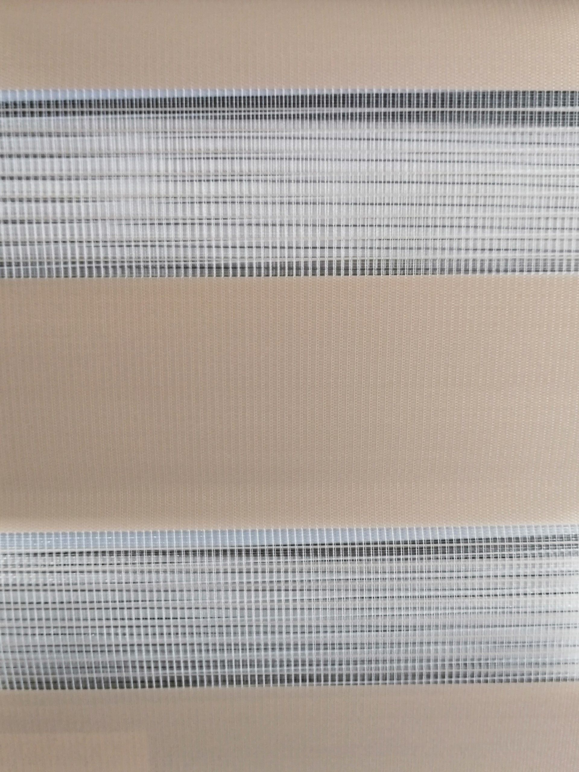 A close up of a striped blind on a window.
