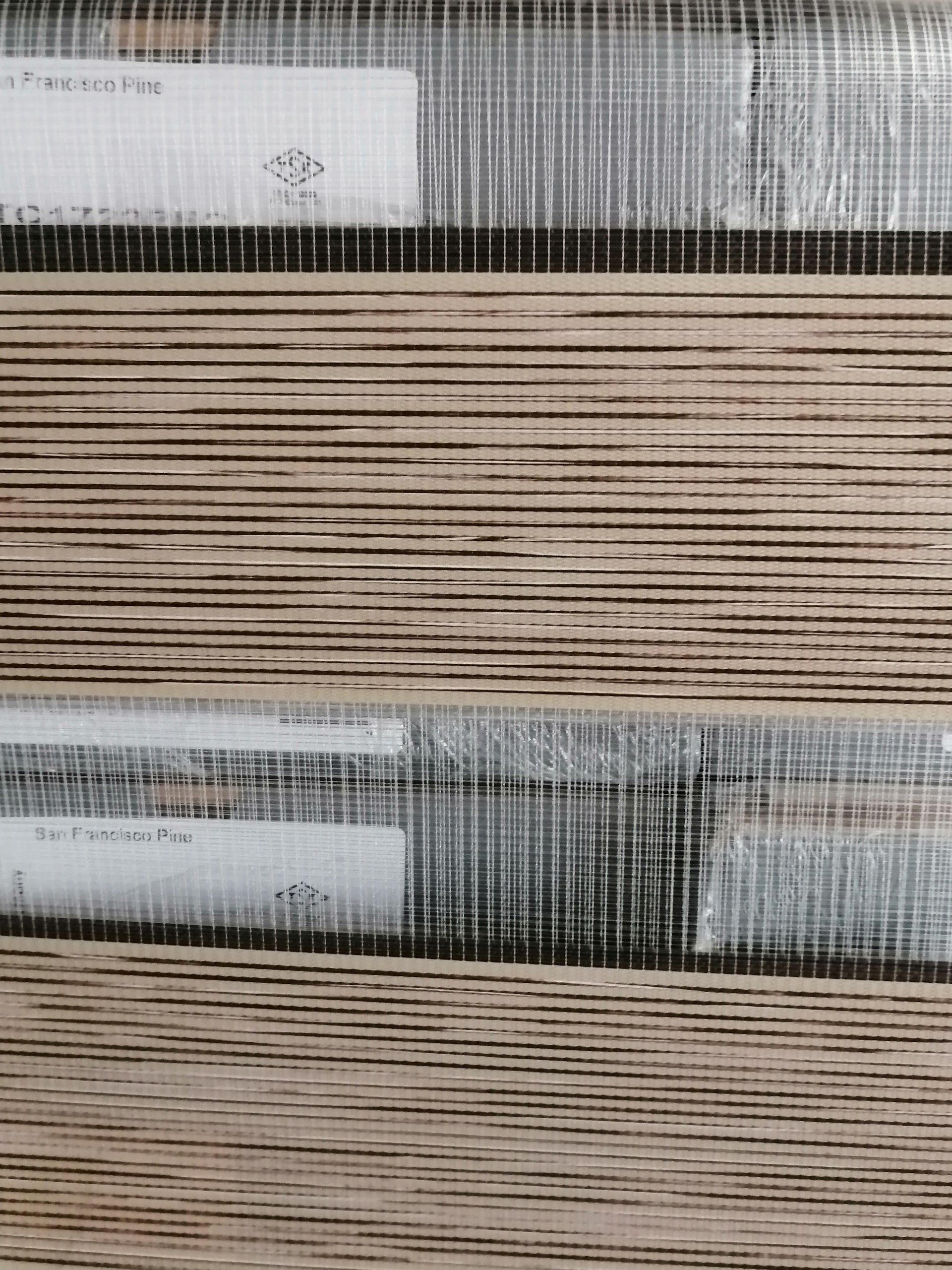 A close up of two rolls of wallpaper on a wall.