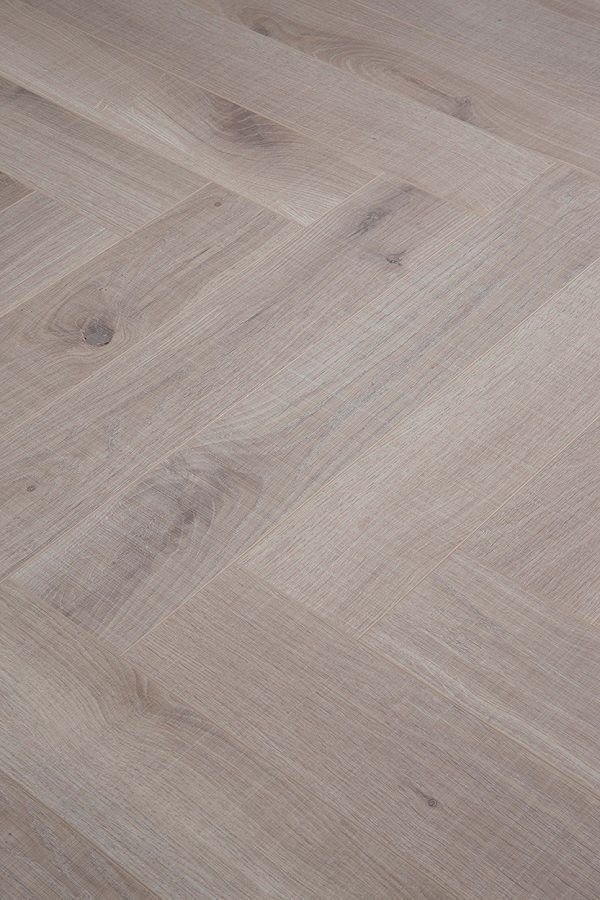 A close up of a wooden floor with a herringbone pattern.