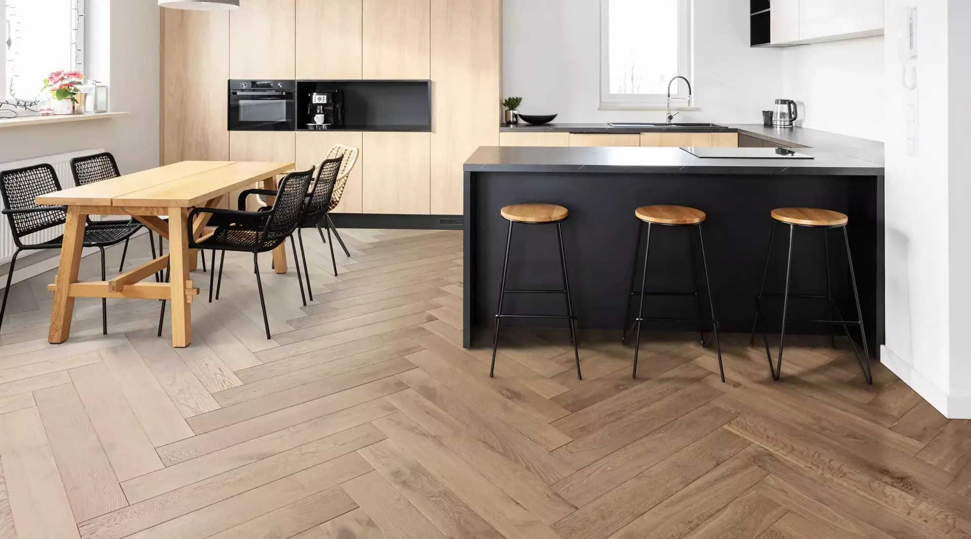 A kitchen with a table and chairs and a wooden floor.