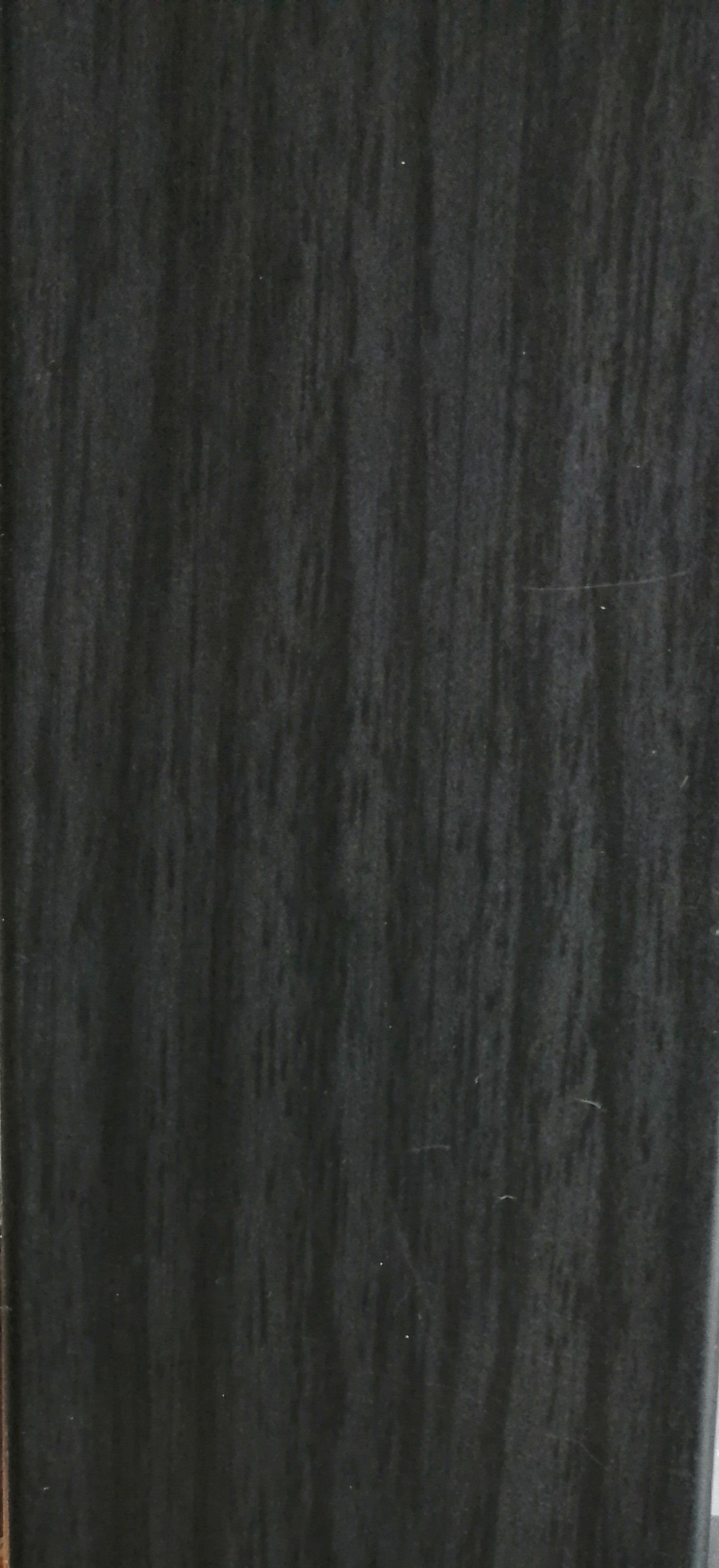 A close up of a black curtain hanging on a wall.