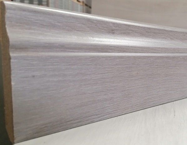 A white wooden molding is sitting on a white surface.