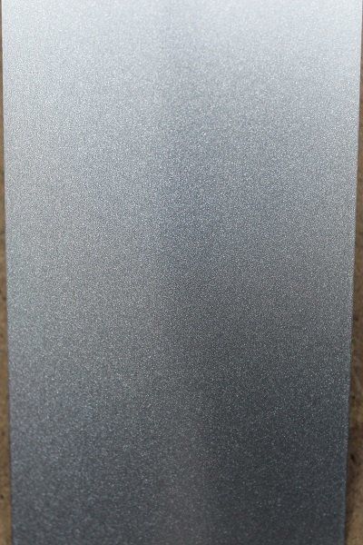 A close up of a metal surface with a gray gradient.