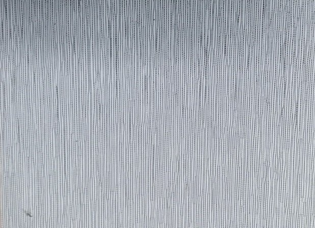 A close up of a stainless steel surface with a striped pattern.