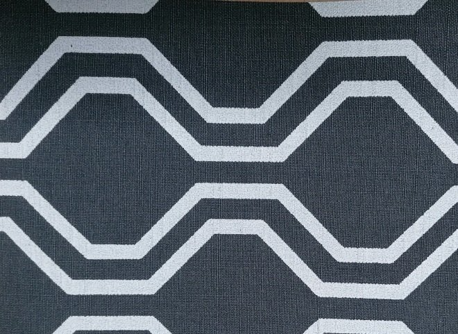 A close up of a black and white rug with a hexagon pattern.