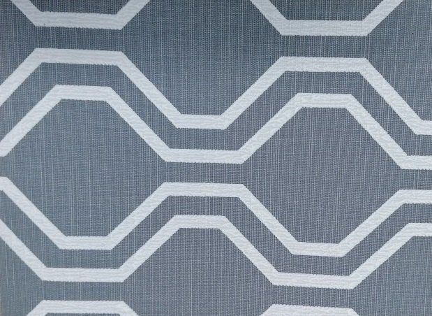 A close up of a gray and white geometric pattern on a fabric.