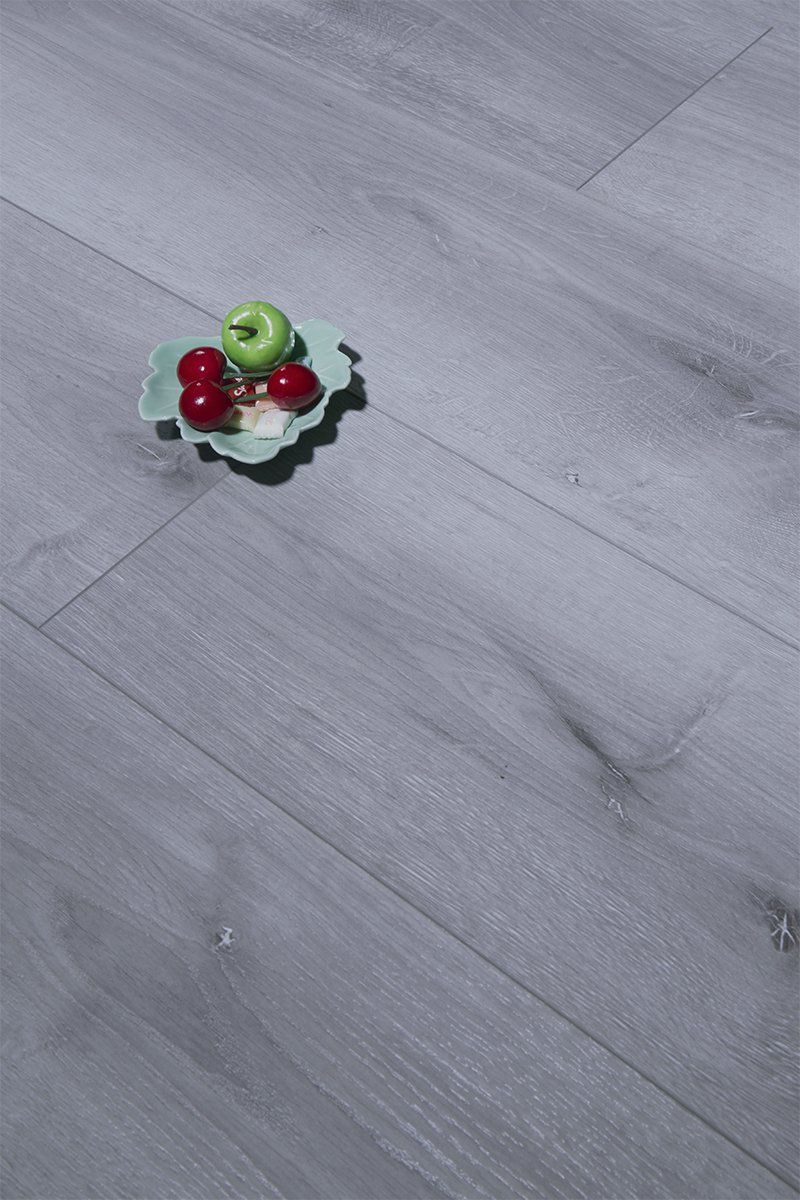 A bowl of fruit is sitting on a wooden floor.