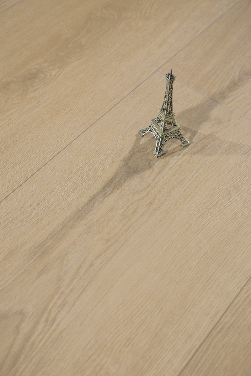A small toy eiffel tower is sitting on a wooden floor.